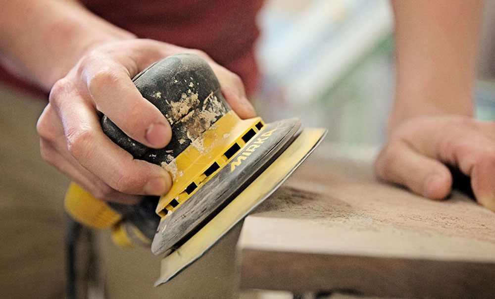 Closeup of a man using a sander